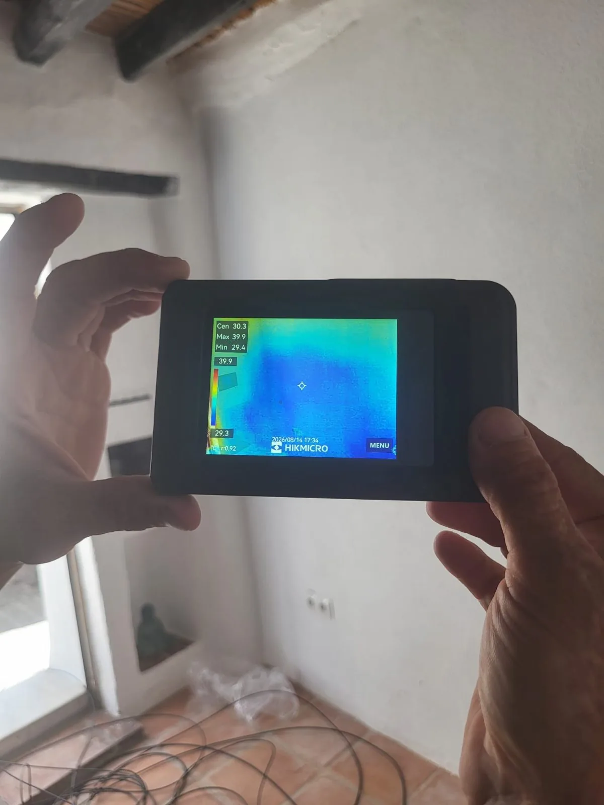 Cámara termográfica en mano para detectar humedad en una pared interior