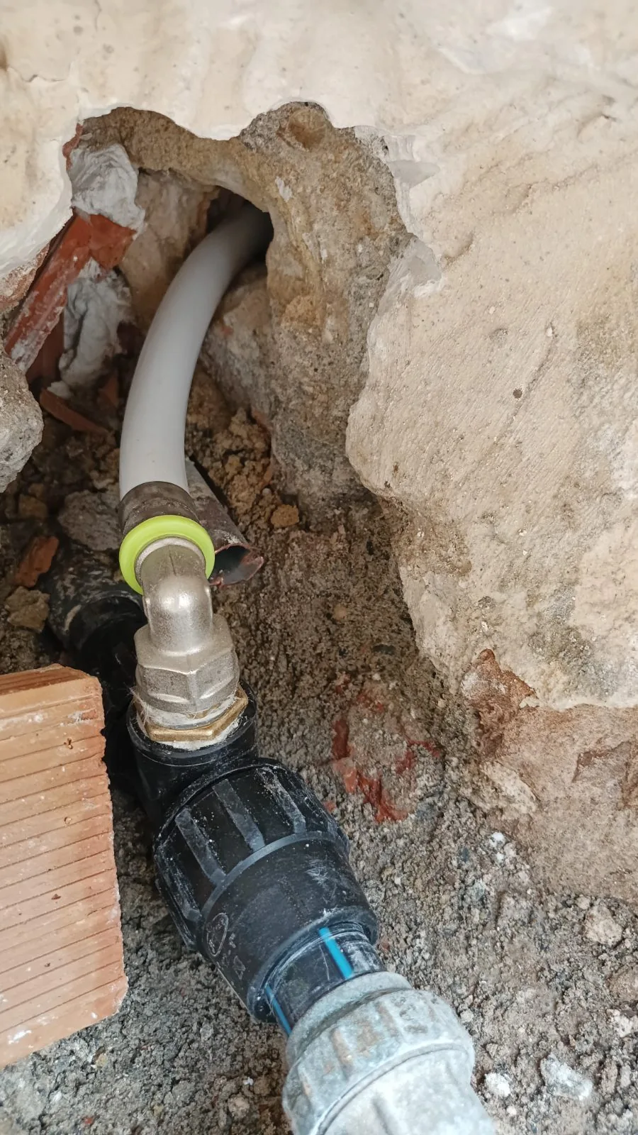 Tubería enterrada con codo y enlace de conexión en una zanja abierta